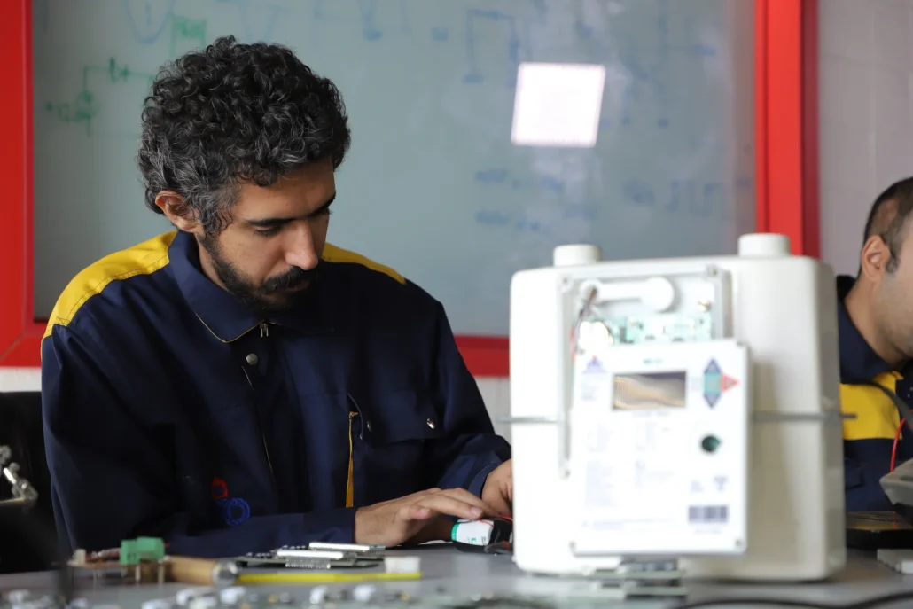 Technician working on smart gas meter electronics at Ekbatan